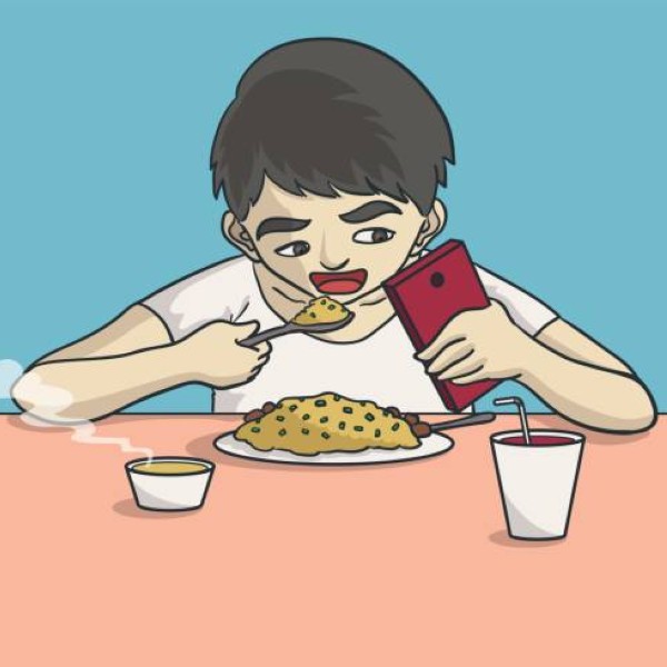 a boy eating and playing on smartphone