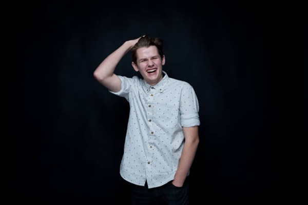 Young handsome man standing in front of black background