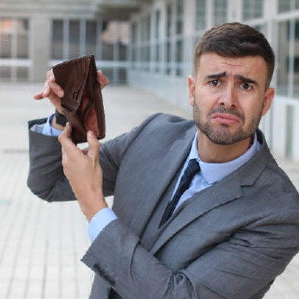Broke businessman showing his empty wallet.