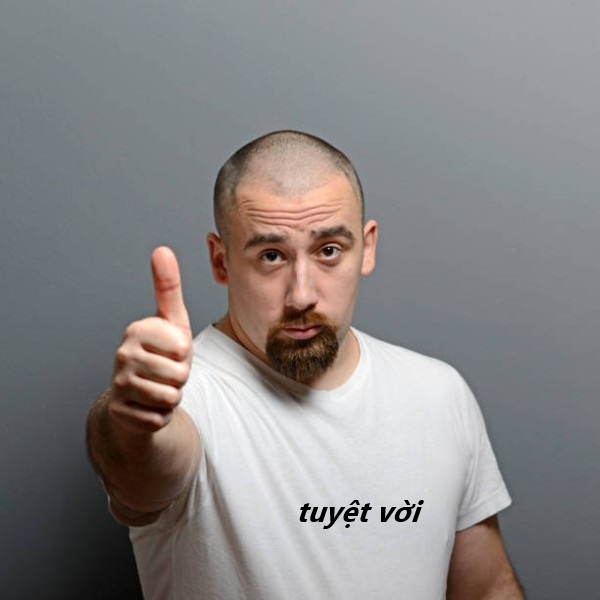 Portrait of a man showing thumb up or ok sign against gray background