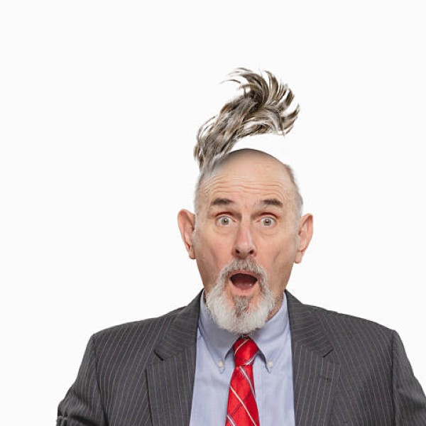 Conceptual image of businessman with toupee flying off, white background