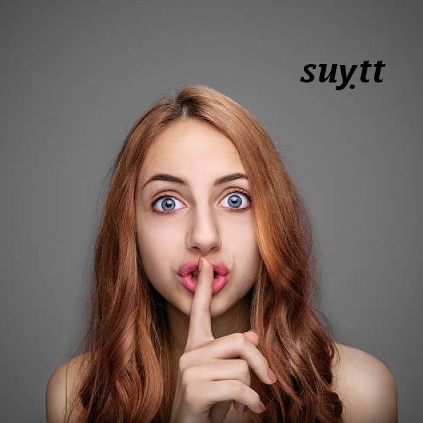Girl keeping finger on her lips , isolated on gray.